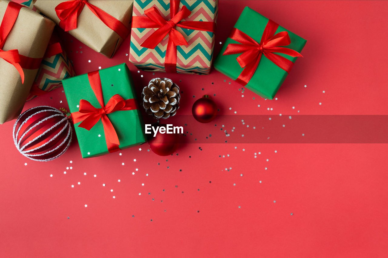 HIGH ANGLE VIEW OF CHRISTMAS DECORATIONS ON RED BOX