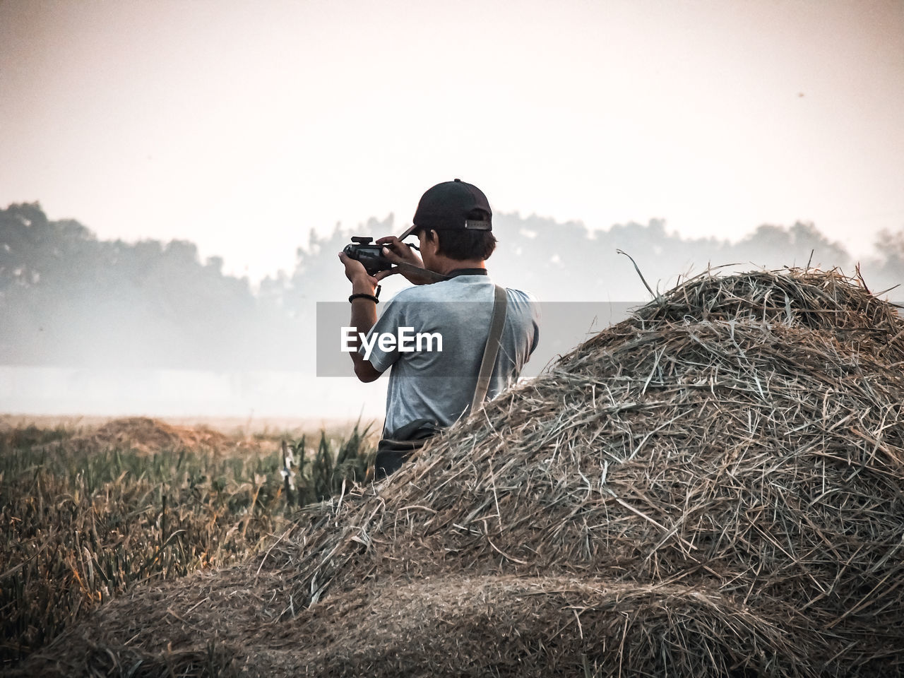 Full length of man photographing on field