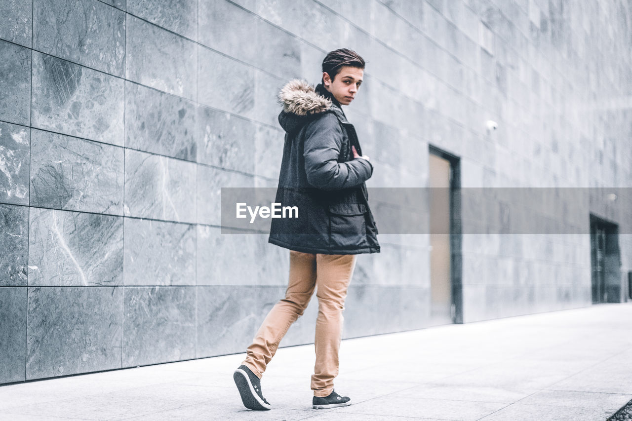 Young man walking on footpath