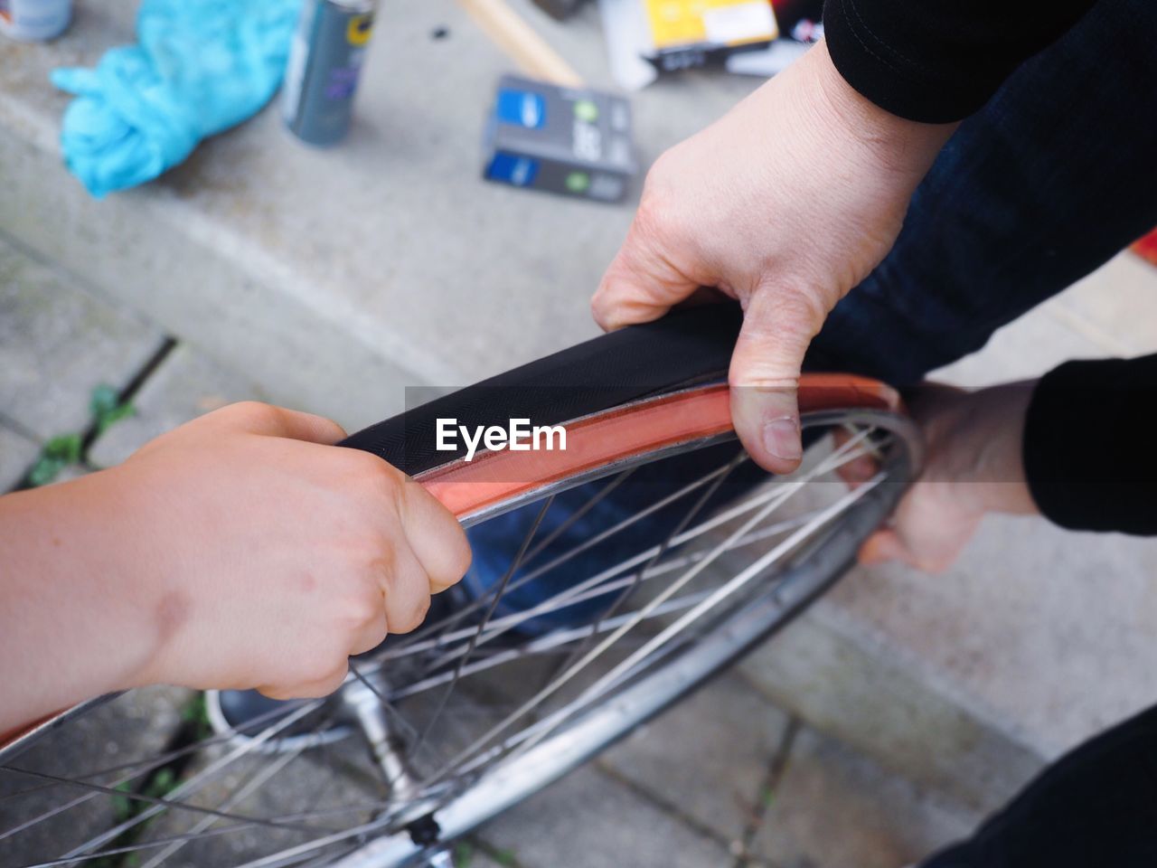 High angle view of hands repairing bicycle wheel