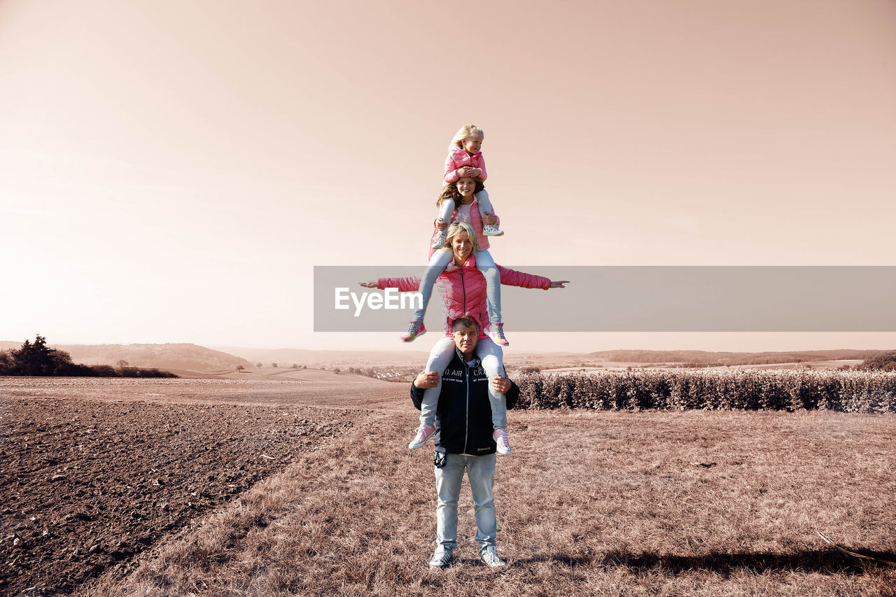 LOW ANGLE VIEW OF PEOPLE STANDING ON DESERT