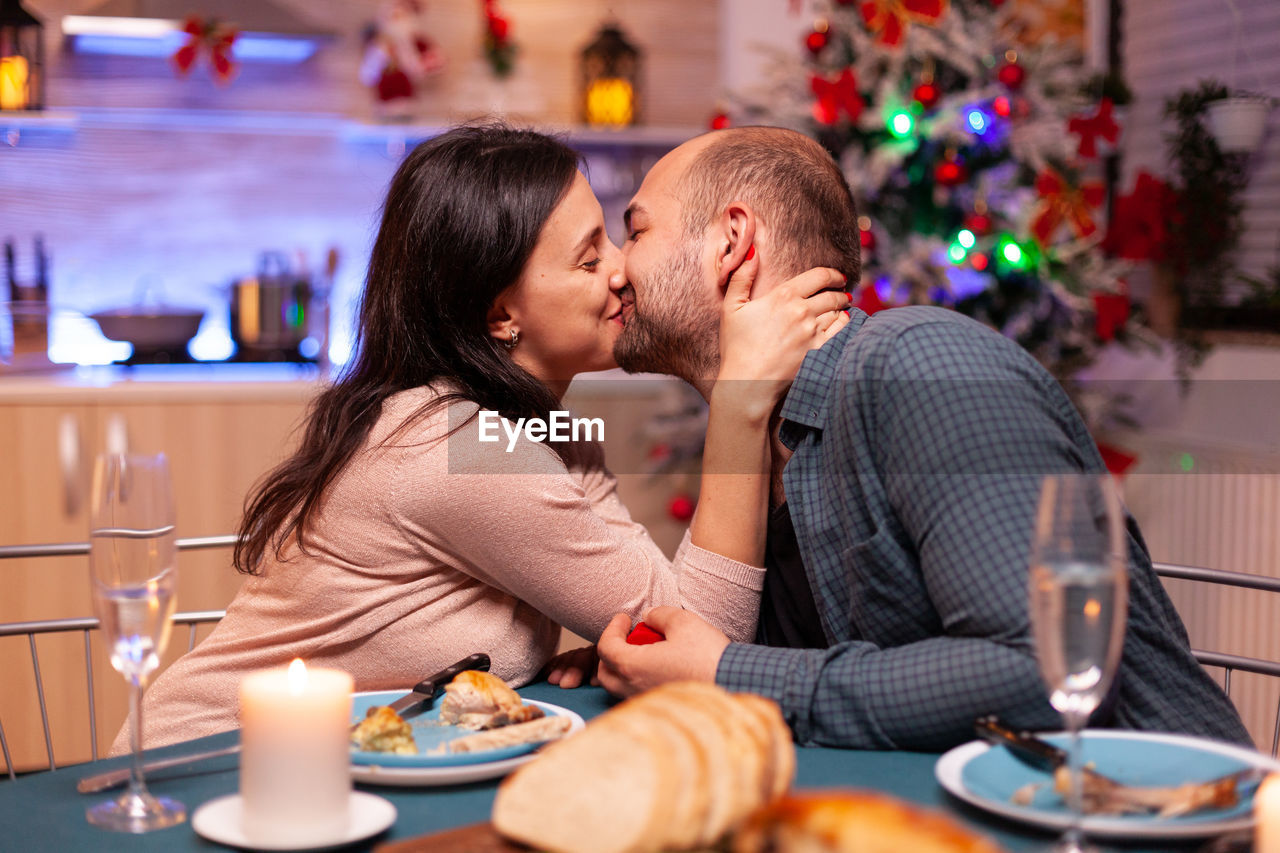 Side view of couple kissing at home