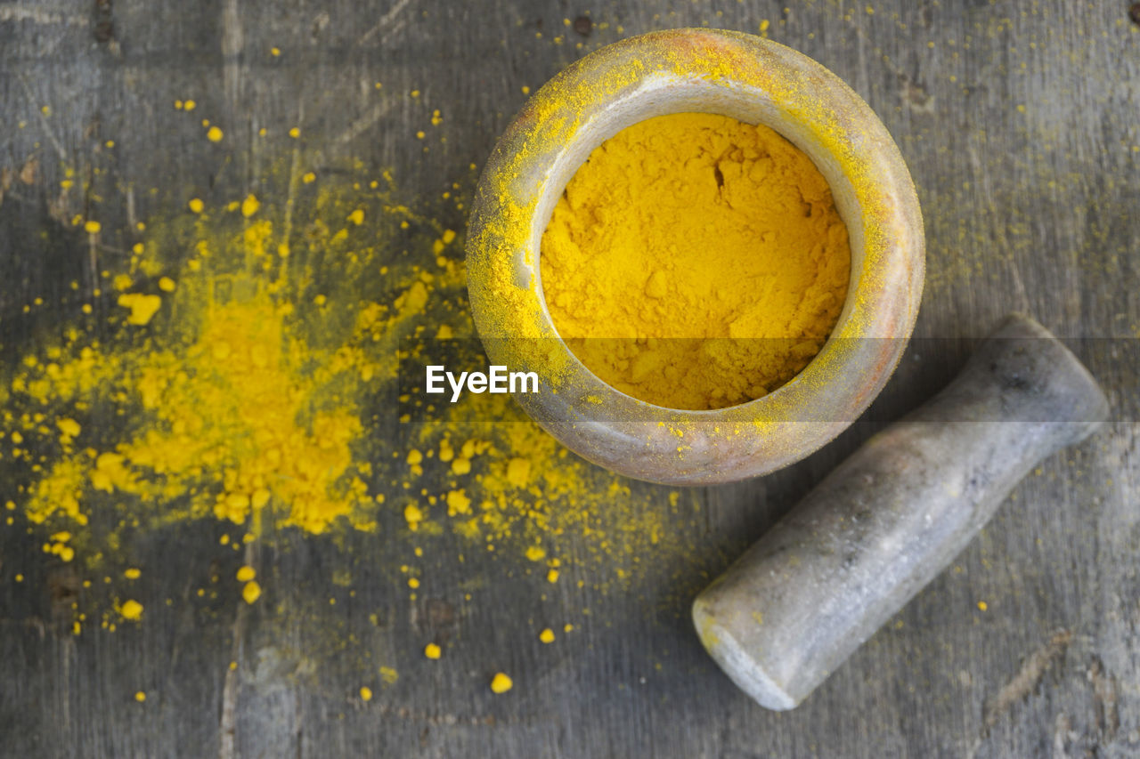 High angle view of turmeric powder on wooden table