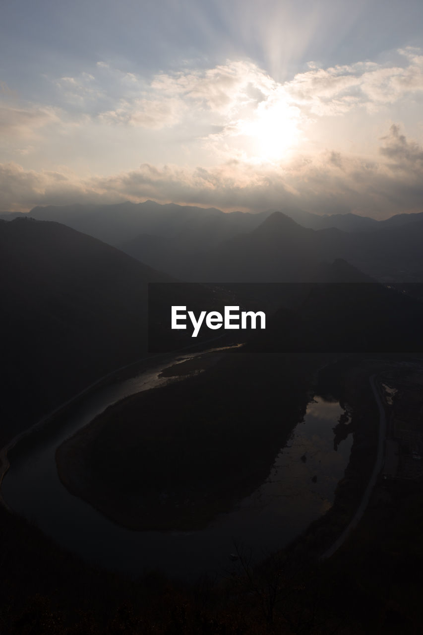 SCENIC VIEW OF LAKE BY SILHOUETTE MOUNTAINS AGAINST SKY DURING SUNSET