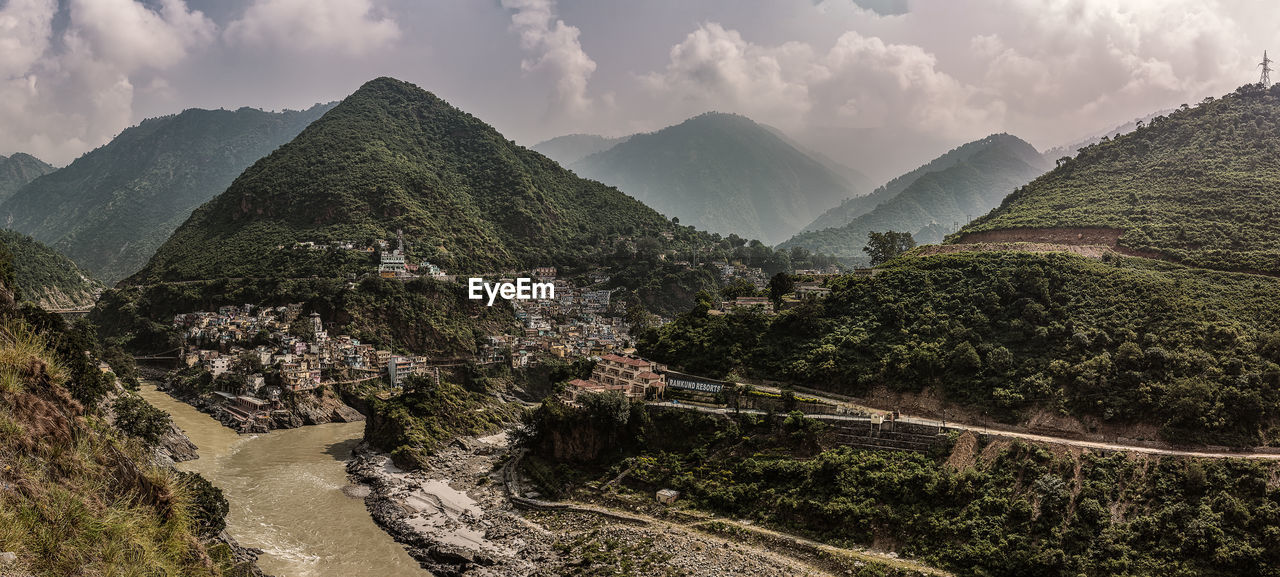 PANORAMIC SHOT OF TREES AND MOUNTAINS AGAINST SKY