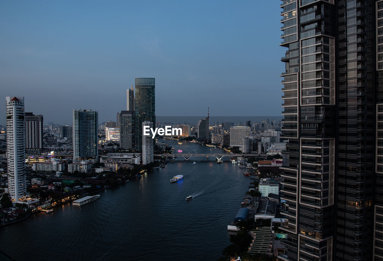 Top view cityscape of bangkok at chao phraya river in evening blue sky