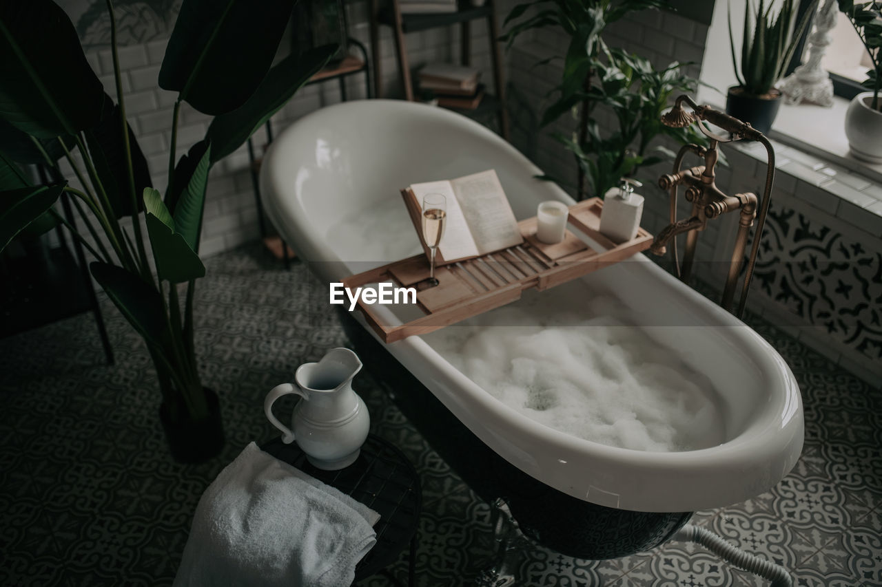 Luxury interior of big bathroom at modern african style with oval bathtub in natural lighting