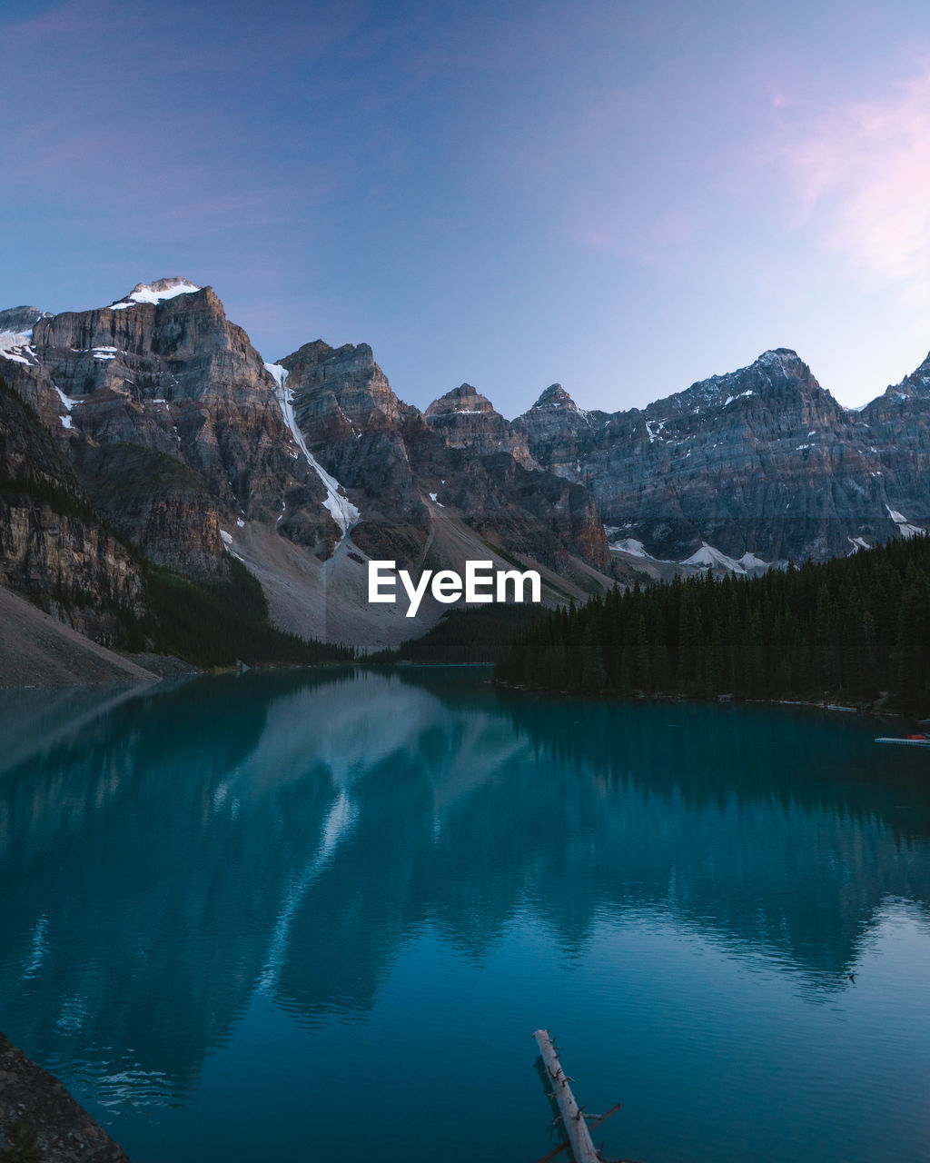 Scenic view of lake and mountains against blue sky