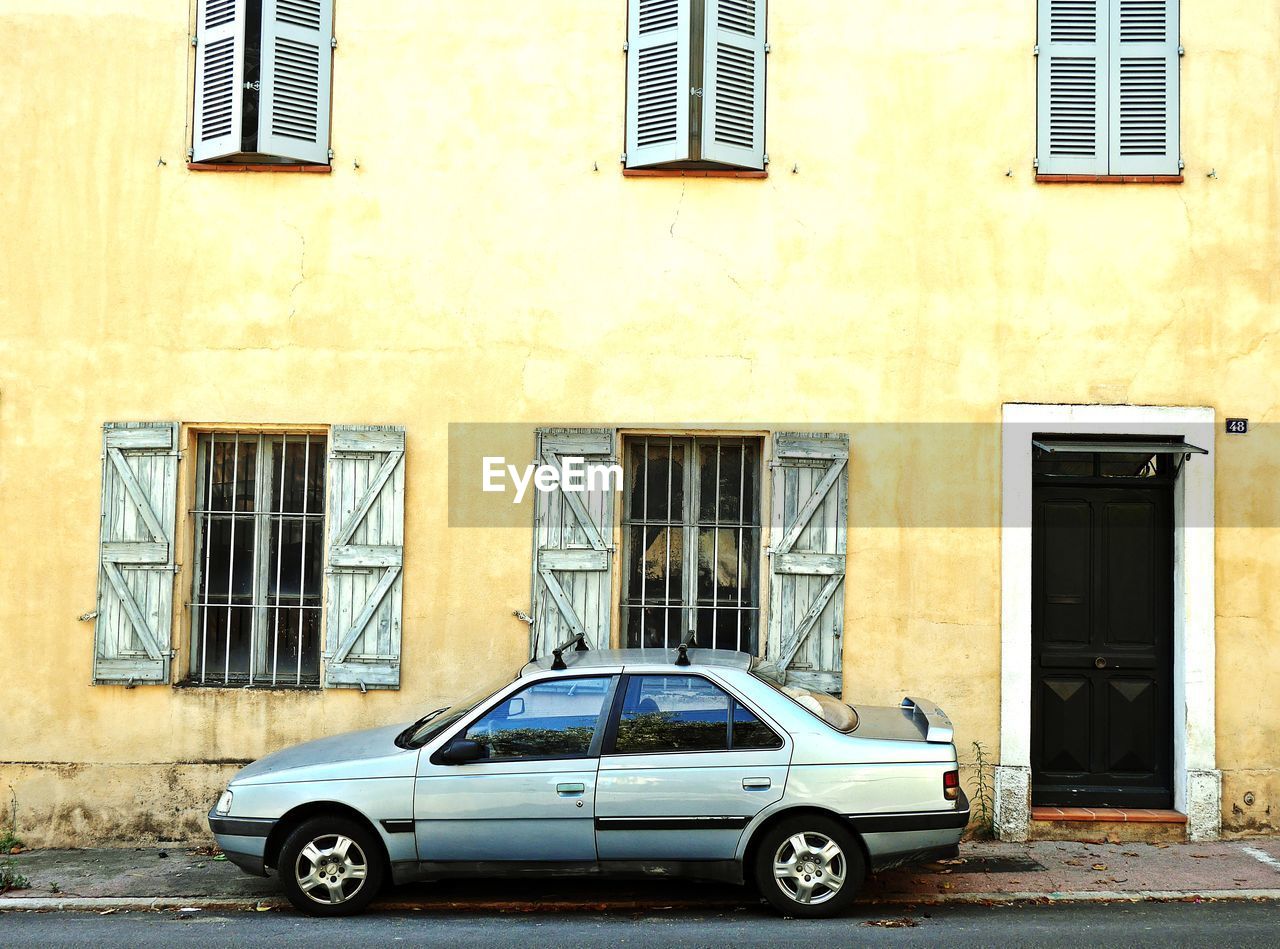 CAR PARKED BY BUILDING