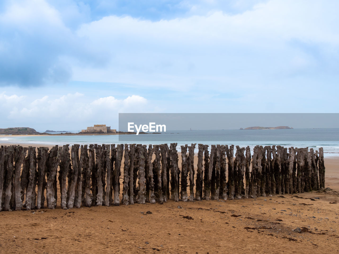 PANORAMIC VIEW OF WOODEN POST ON BEACH AGAINST SKY