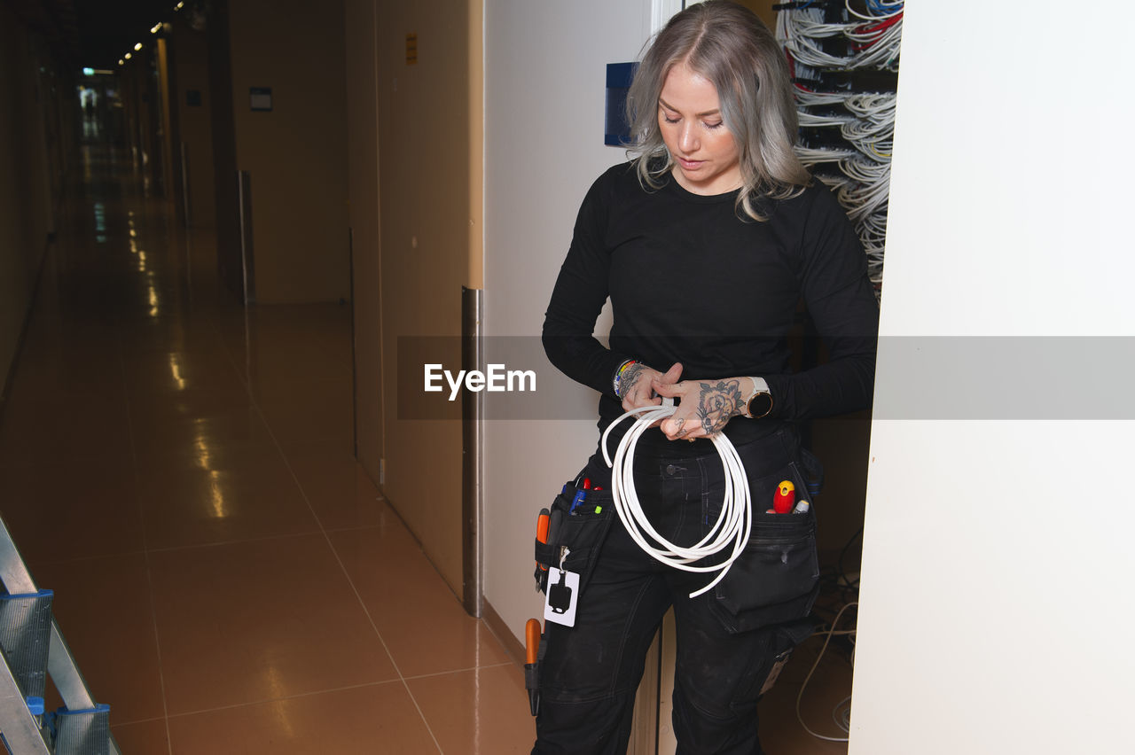 Female electrician holding cable