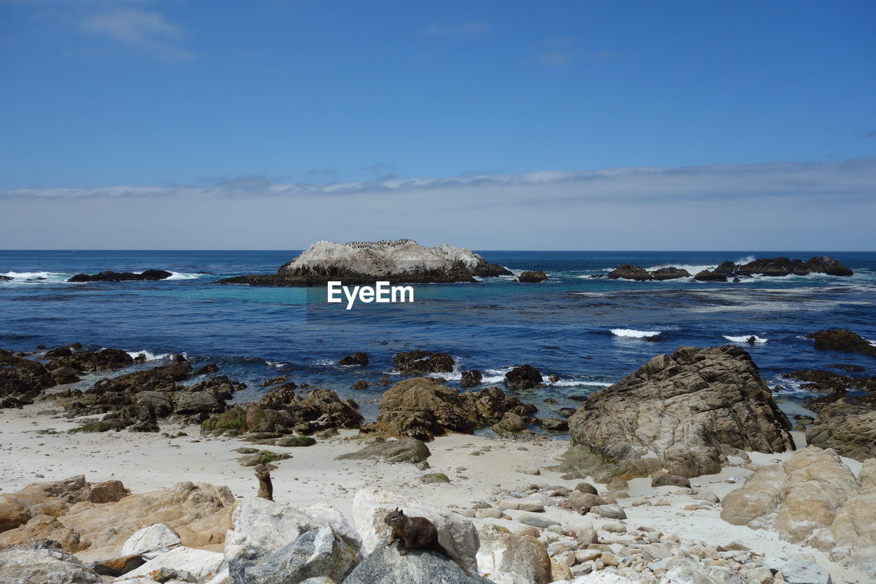 ROCKS ON SHORE AGAINST SKY