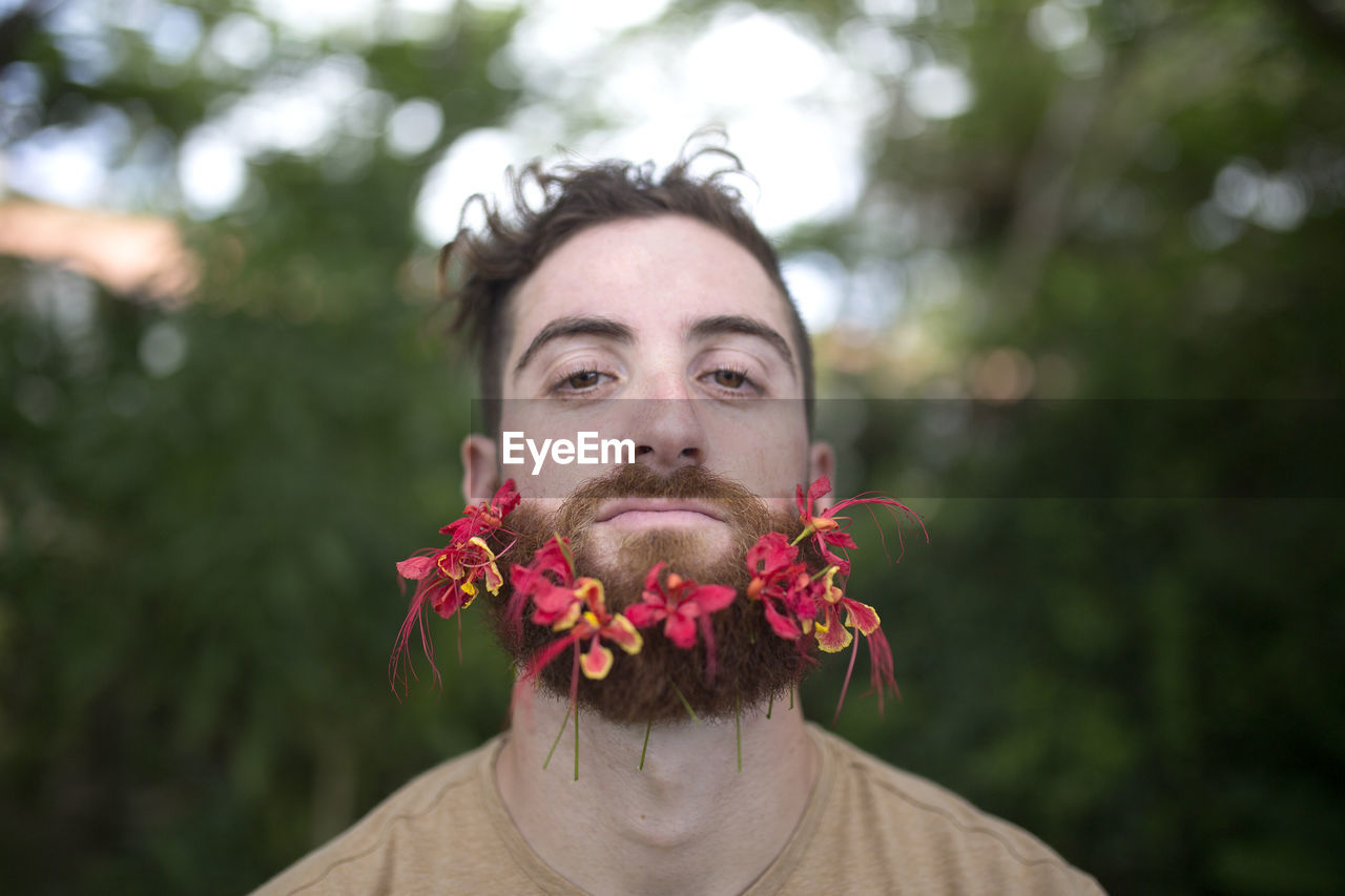 Man with tropical flowers in beard