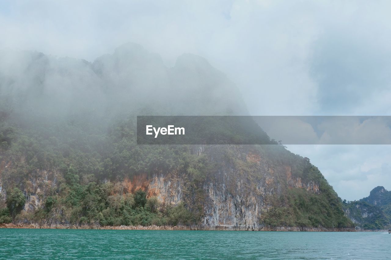 Scenic view of sea and mountains against sky