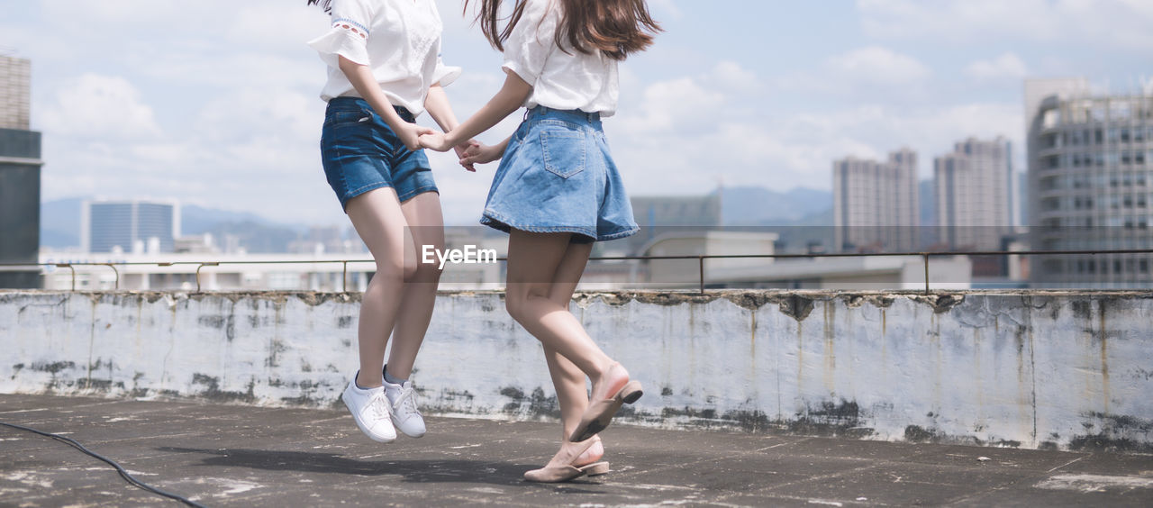 Low section of women dancing on rooftop