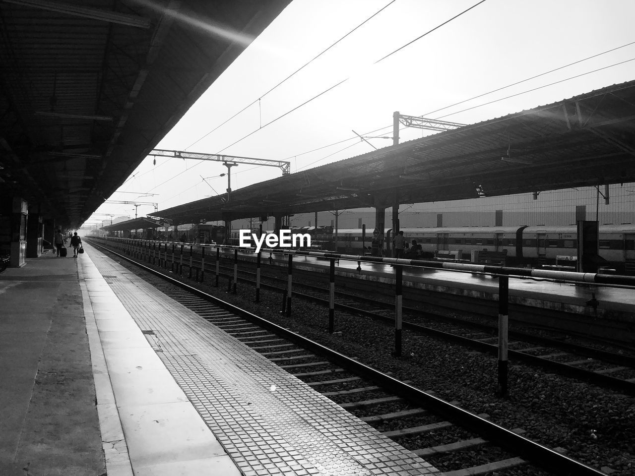 transportation, rail transportation, track, railroad track, mode of transportation, railroad station, railroad station platform, monochrome, black and white, public transportation, train station, line, transport, architecture, travel, monochrome photography, railway, vehicle, white, train, black, built structure, sky, nature, metropolitan area, no people, day, public transport, outdoors, city, station