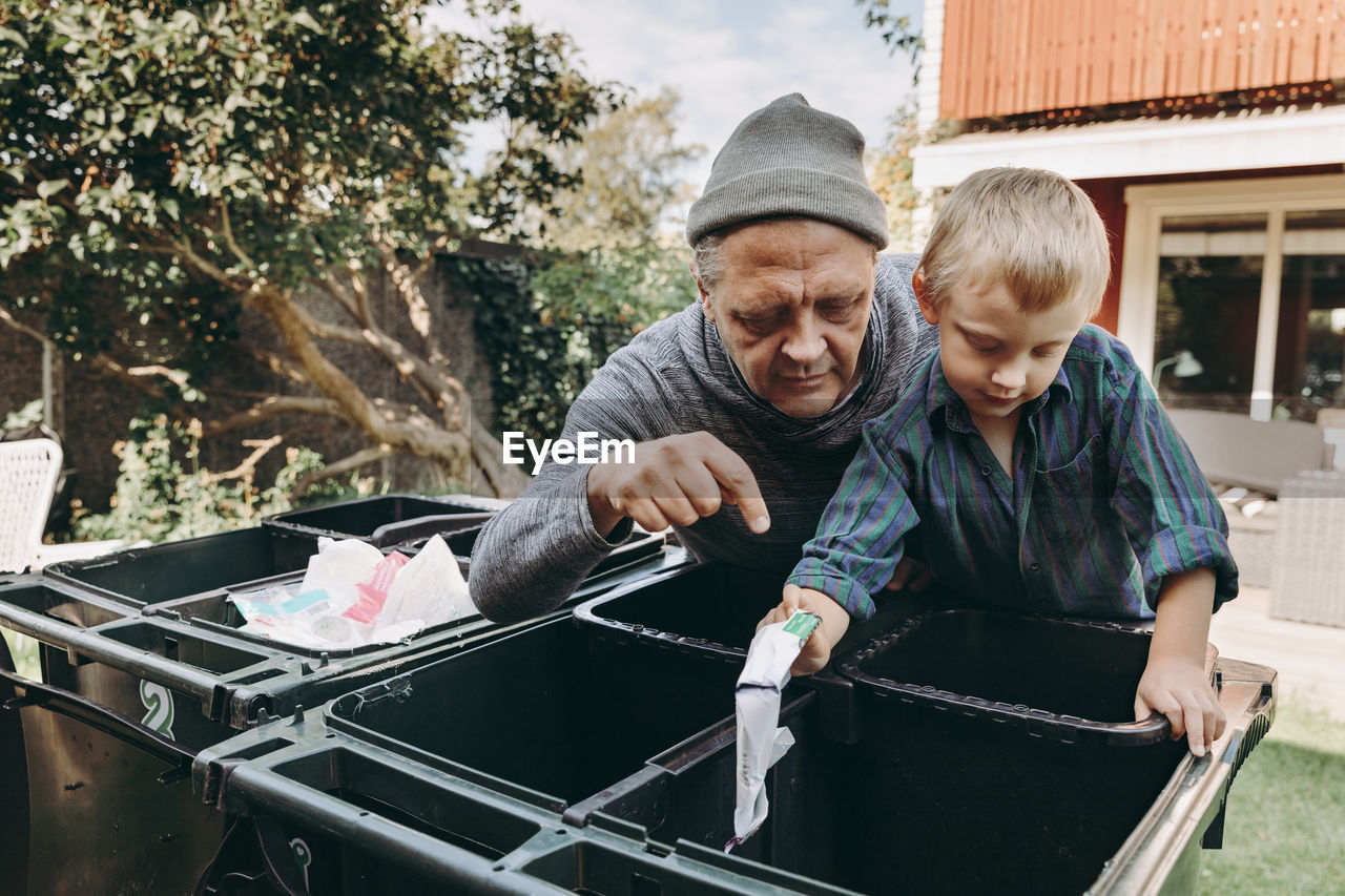 Father and son recycling waste in garden