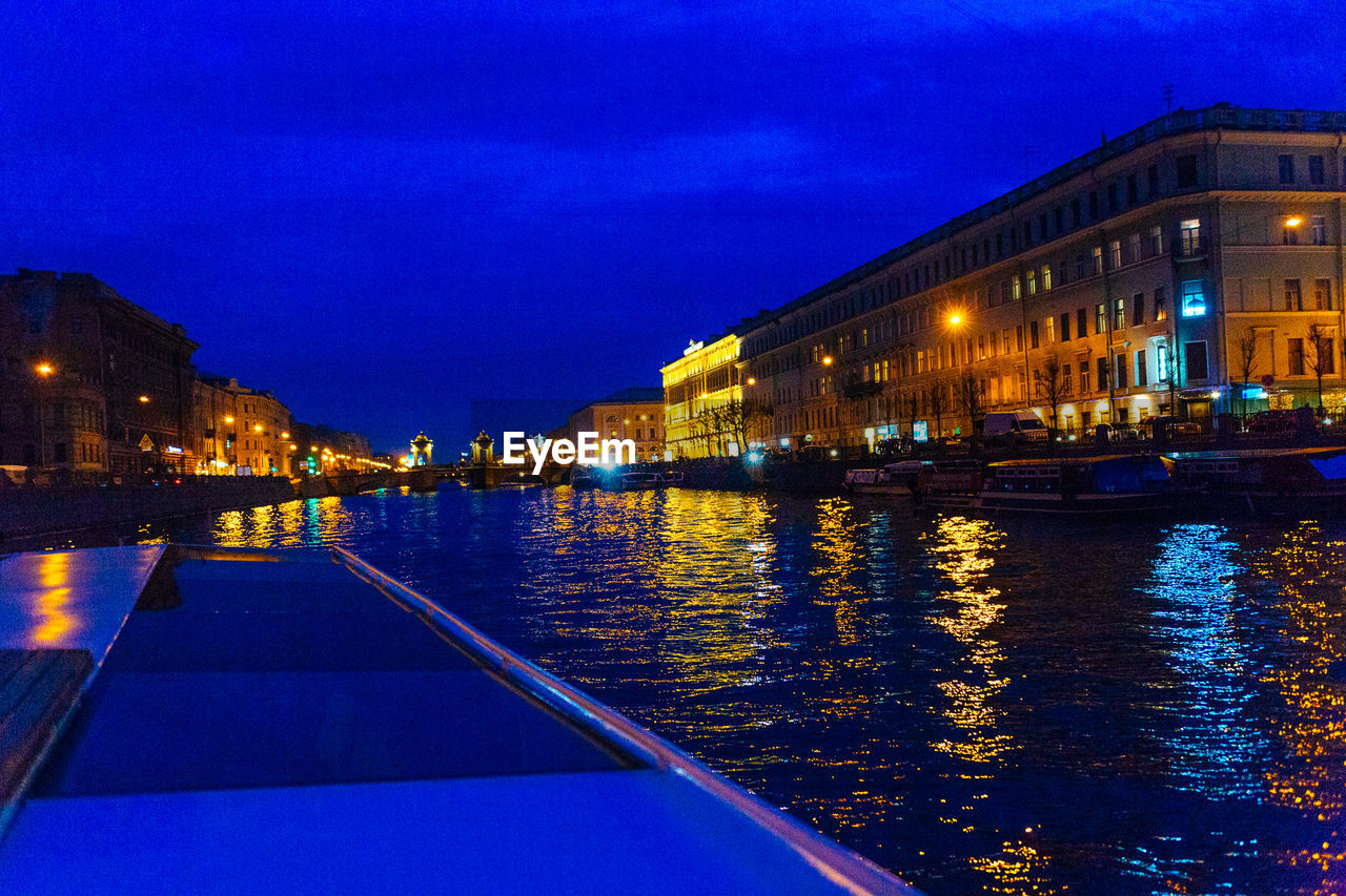 ILLUMINATED BUILDINGS WITH WATERFRONT AT NIGHT