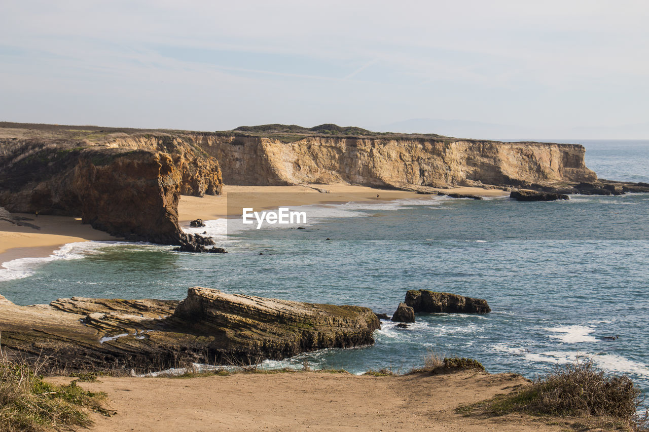 Rock formations by sea against sky