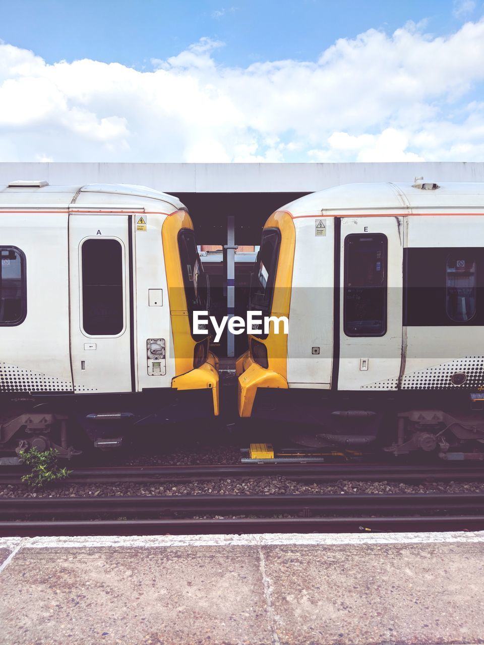 Trains at railroad station platform against sky