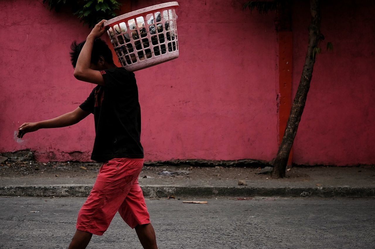 Full length of man carrying laundry basket