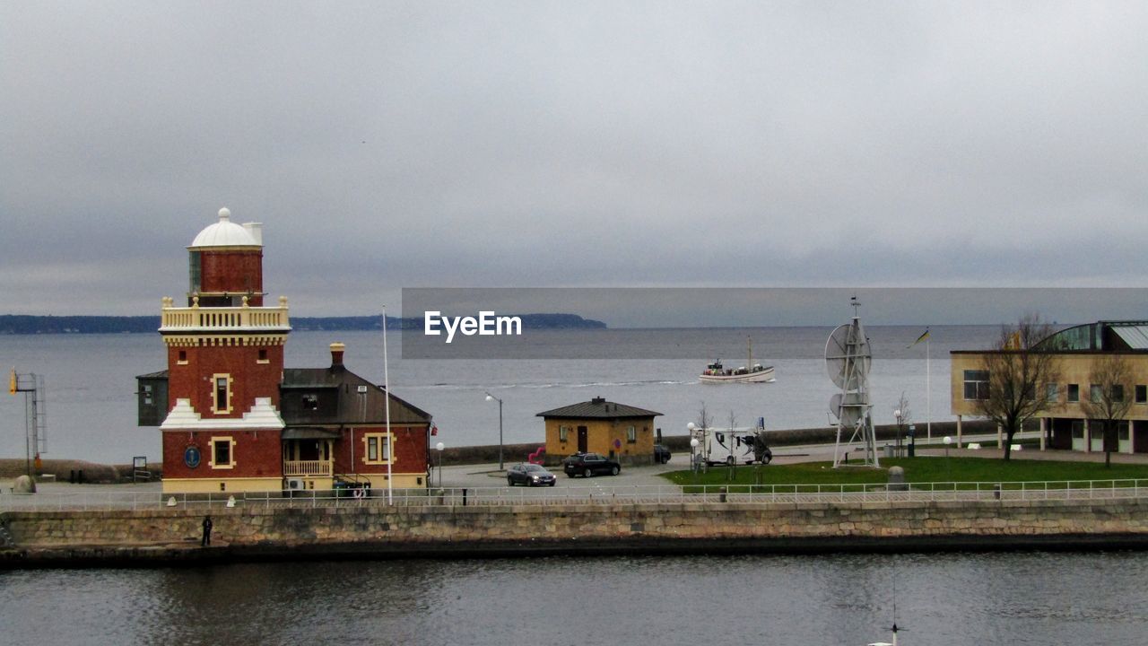 BUILDINGS AT WATERFRONT AGAINST SKY