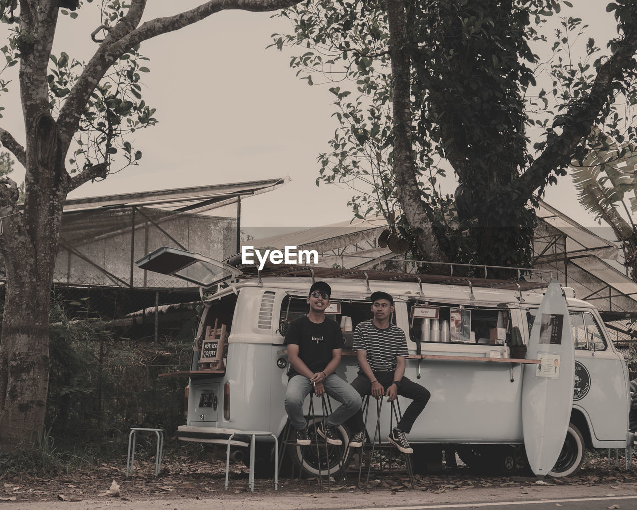 PEOPLE SITTING ON CART BY TREES