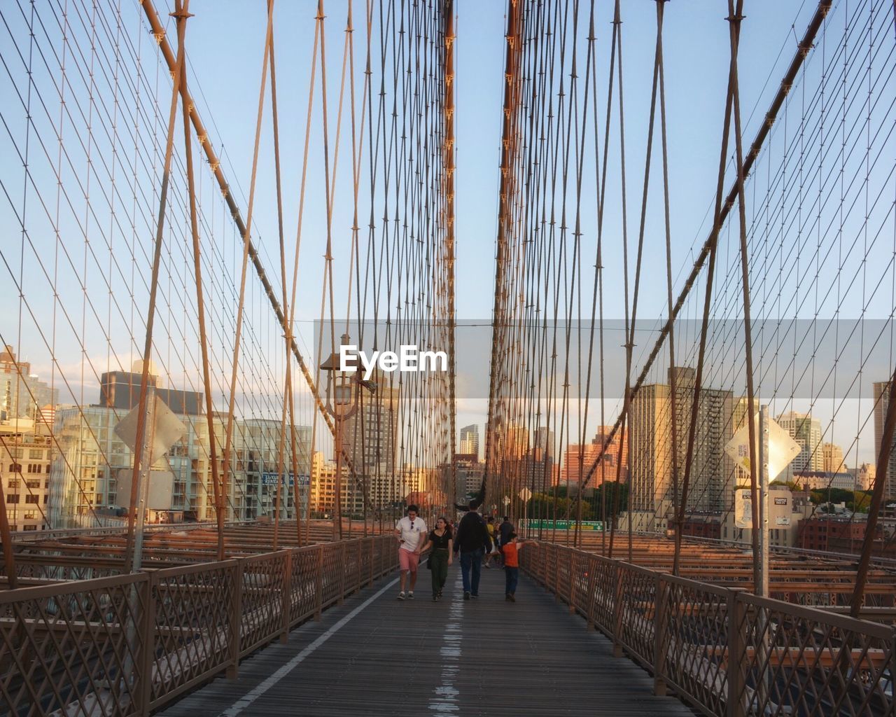 Tourist walking on suspension bridge in city