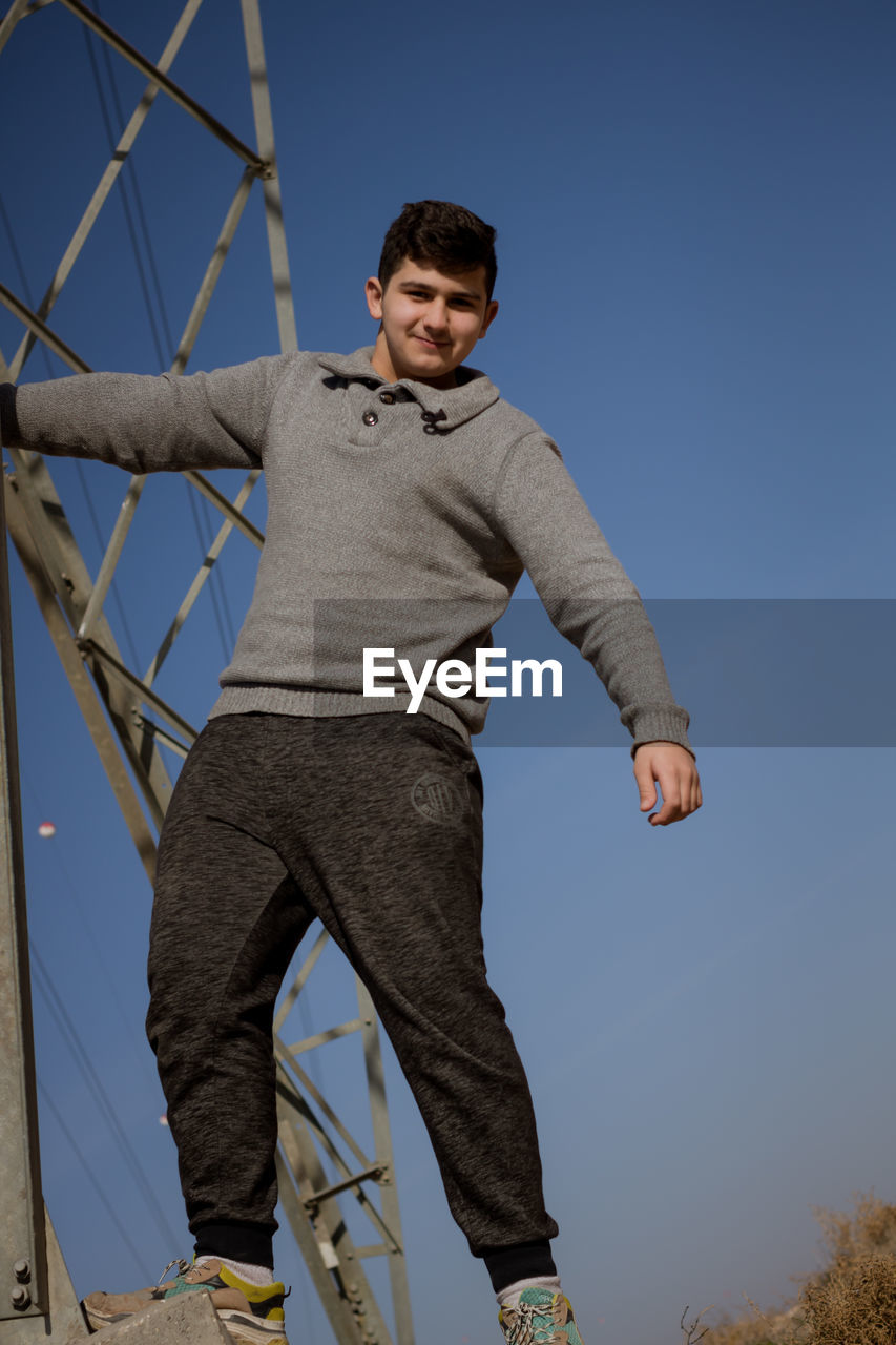 PORTRAIT OF SMILING MAN AGAINST CLEAR SKY