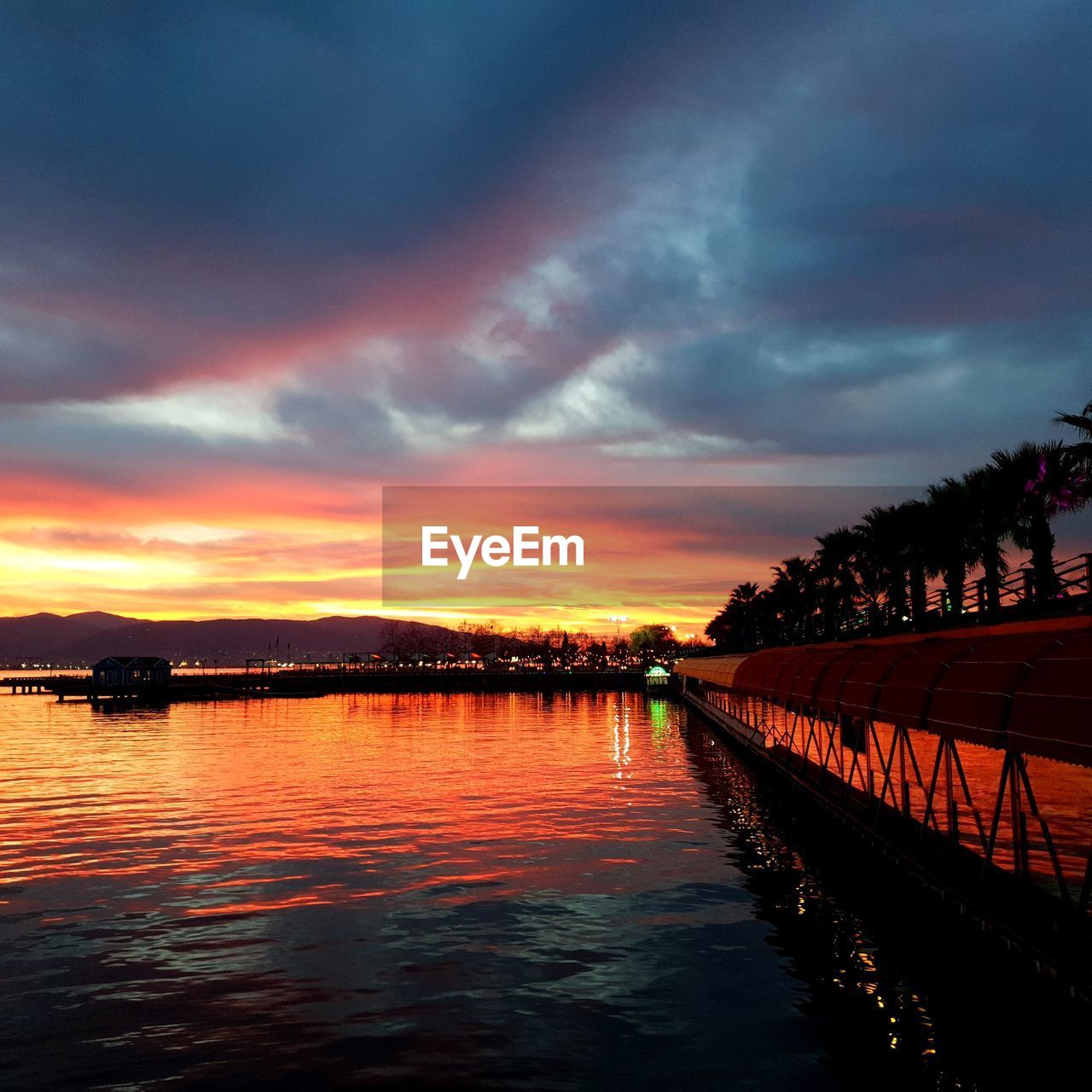 SCENIC VIEW OF LAKE AGAINST ORANGE SKY