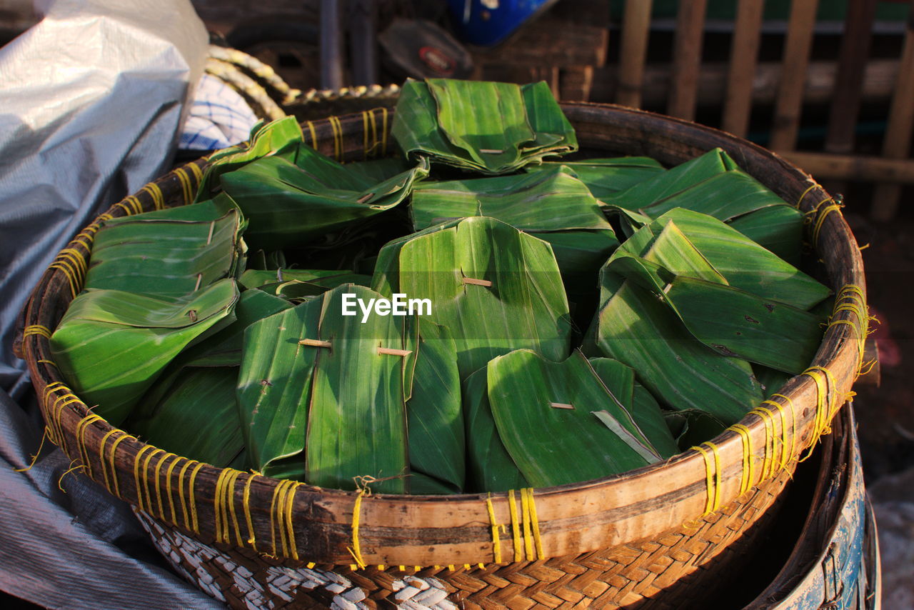 CLOSE-UP OF WICKER BASKET WITH VEGETABLES IN BACKGROUND