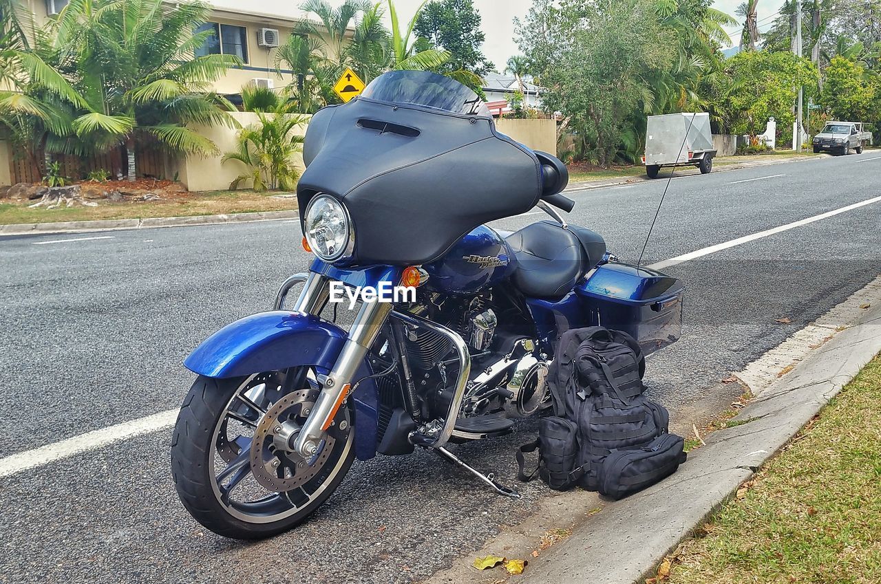 MOTORCYCLE ON ROAD BY TREE