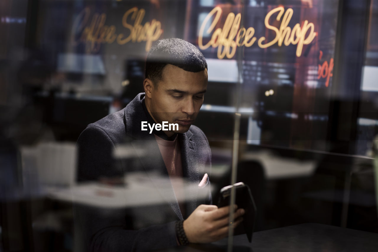 Man using cell phone in cafe