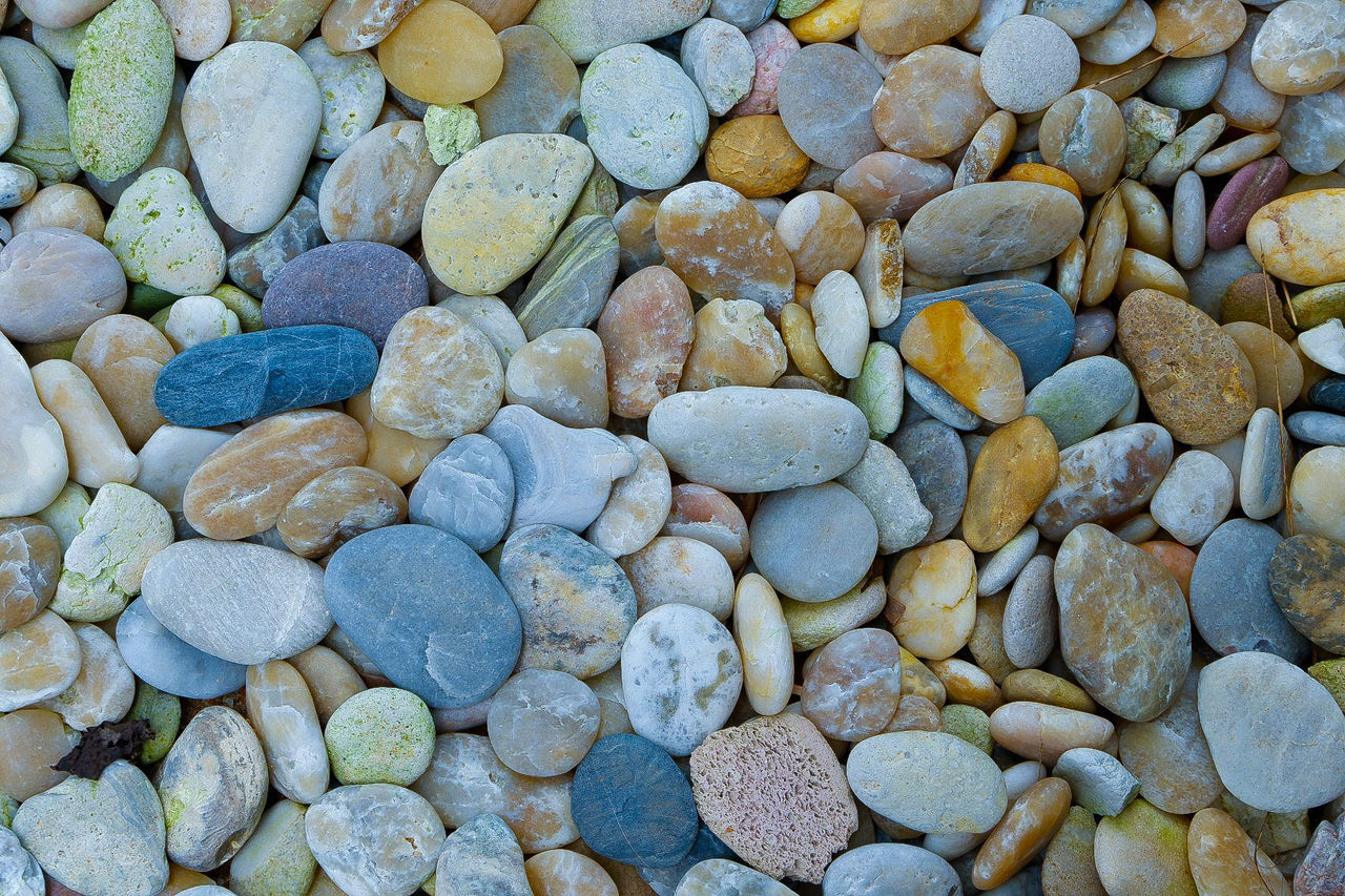 FULL FRAME SHOT OF PEBBLES ON ROCKS