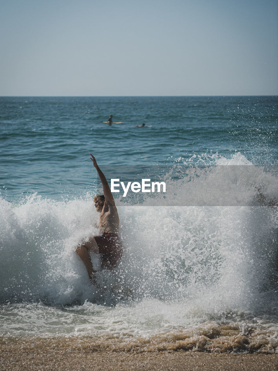 Man surfing in sea against clear sky