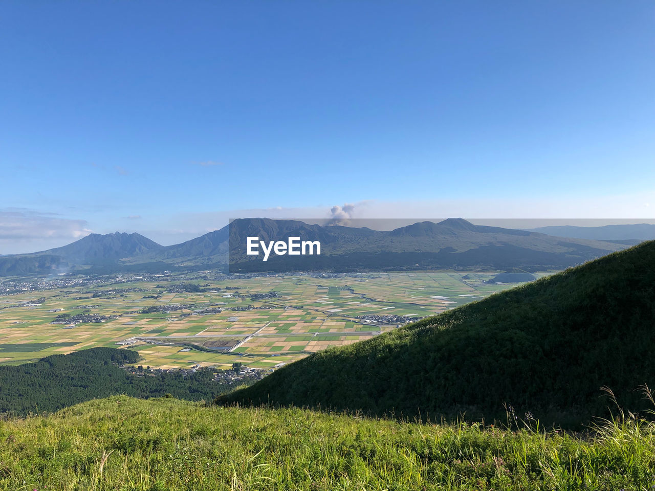 Scenic view of landscape and mountains against blue sky