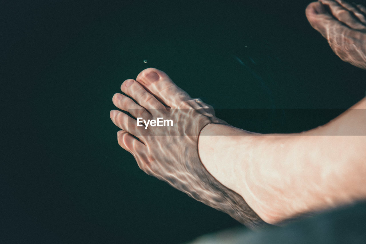 Low section of woman feet in water at lake