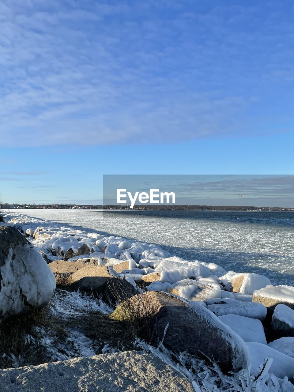 Scenic view of sea against clear blue sky during winter