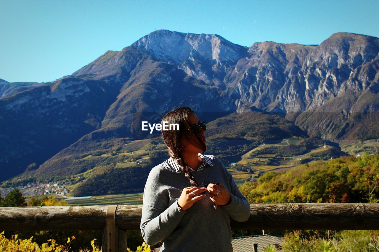 Young woman standing against mountains