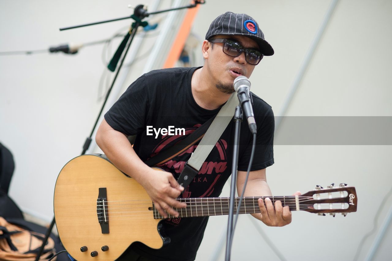 YOUNG MAN PLAYING GUITAR IN MUSIC