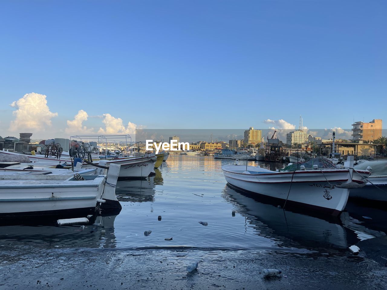 water, nautical vessel, transportation, sky, sea, mode of transportation, dock, moored, harbor, vehicle, boat, nature, architecture, marina, city, ship, watercraft, no people, travel destinations, coast, building exterior, travel, blue, beach, clear sky, land, built structure, reflection, landscape, outdoors, building, day, bay, pier, tourism, tranquility, beauty in nature, copy space