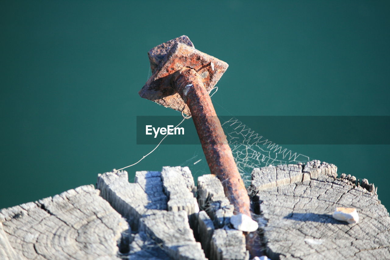 Close-up of rusty metal on wooden post