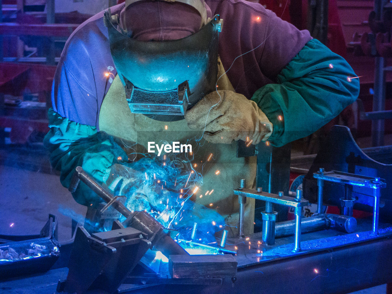 Close up portrait of man welding with sparks