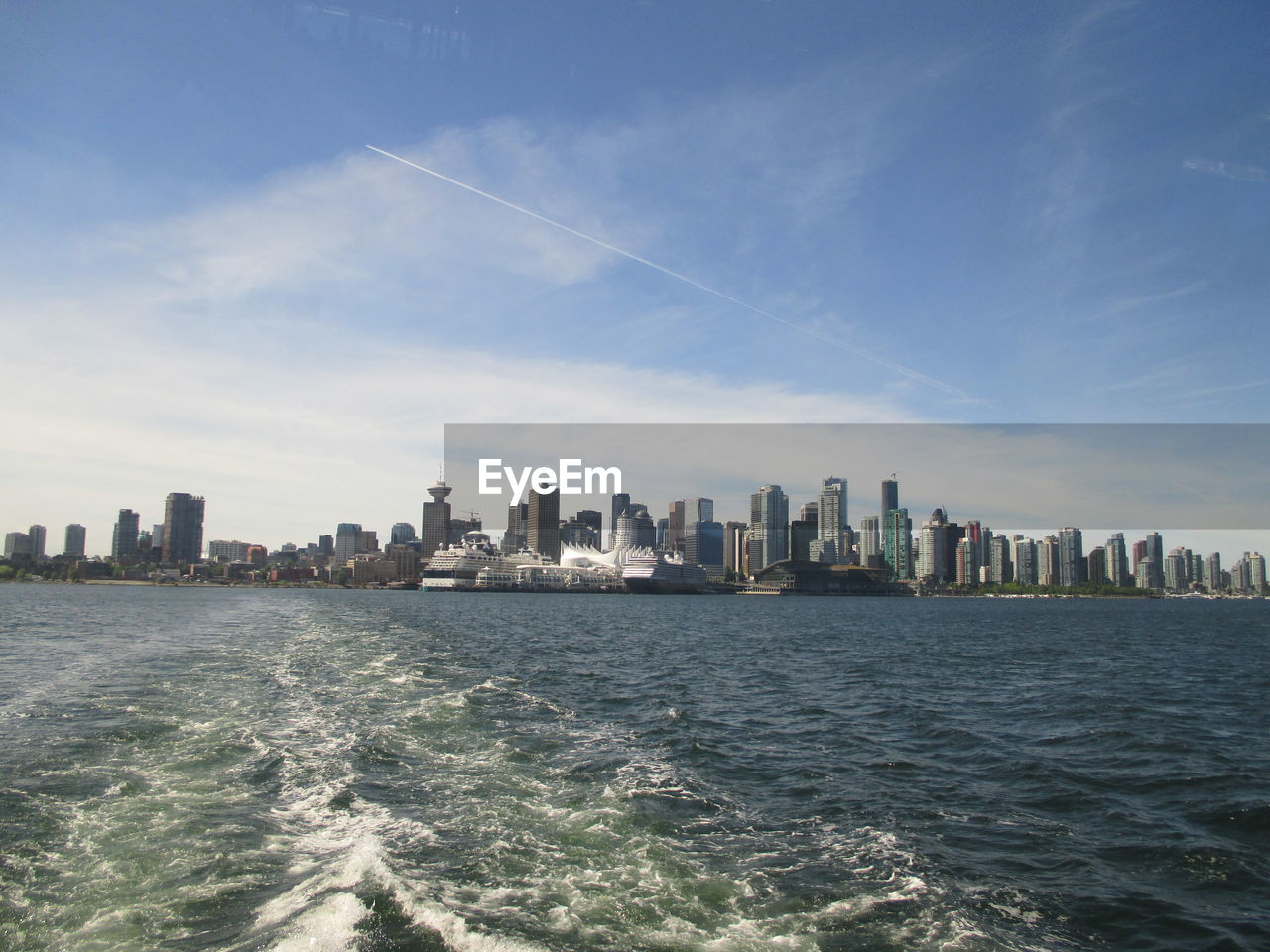 SCENIC VIEW OF SEA BY CITYSCAPE AGAINST SKY