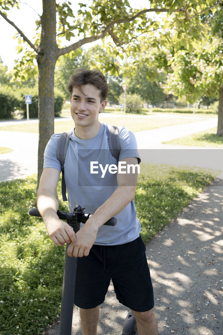 portrait of young man standing on footpath