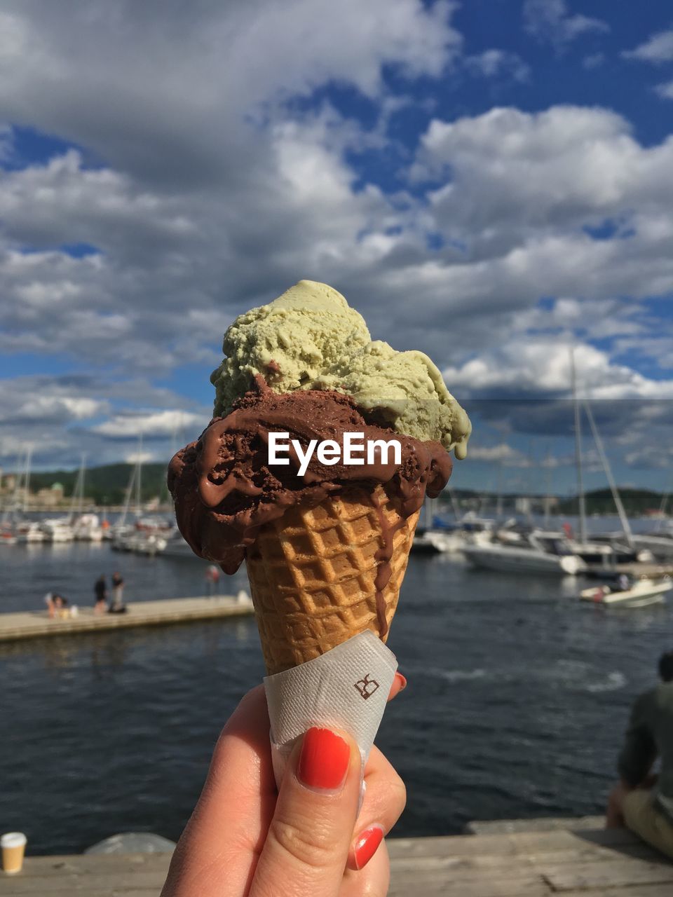 CLOSE-UP OF HAND HOLDING ICE CREAM CONE