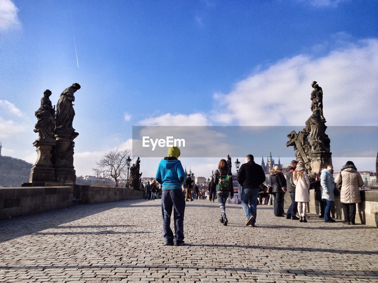 People on charles bridge against cloudy blue sky