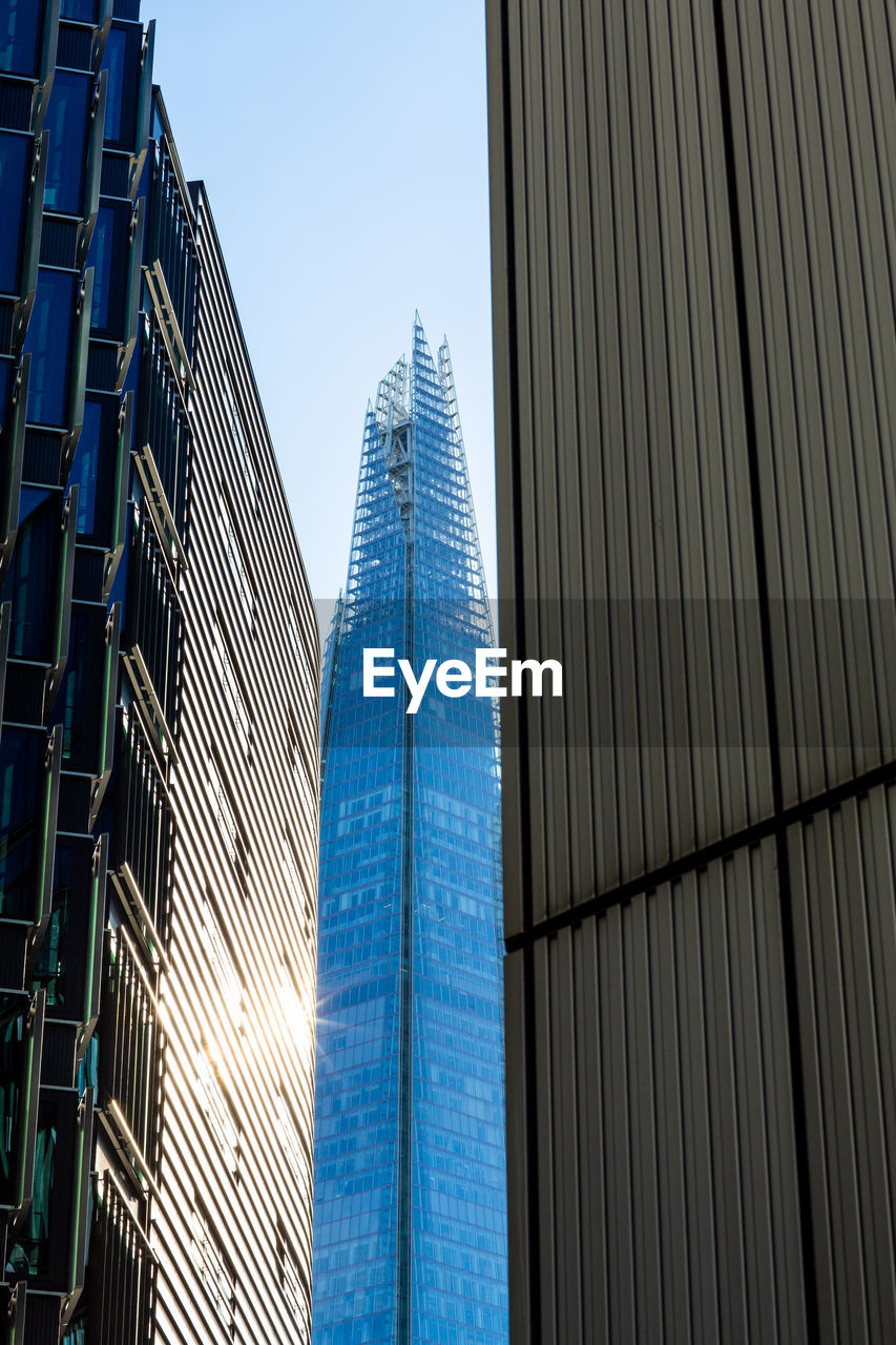 Low angle view of modern buildings against clear blue sky