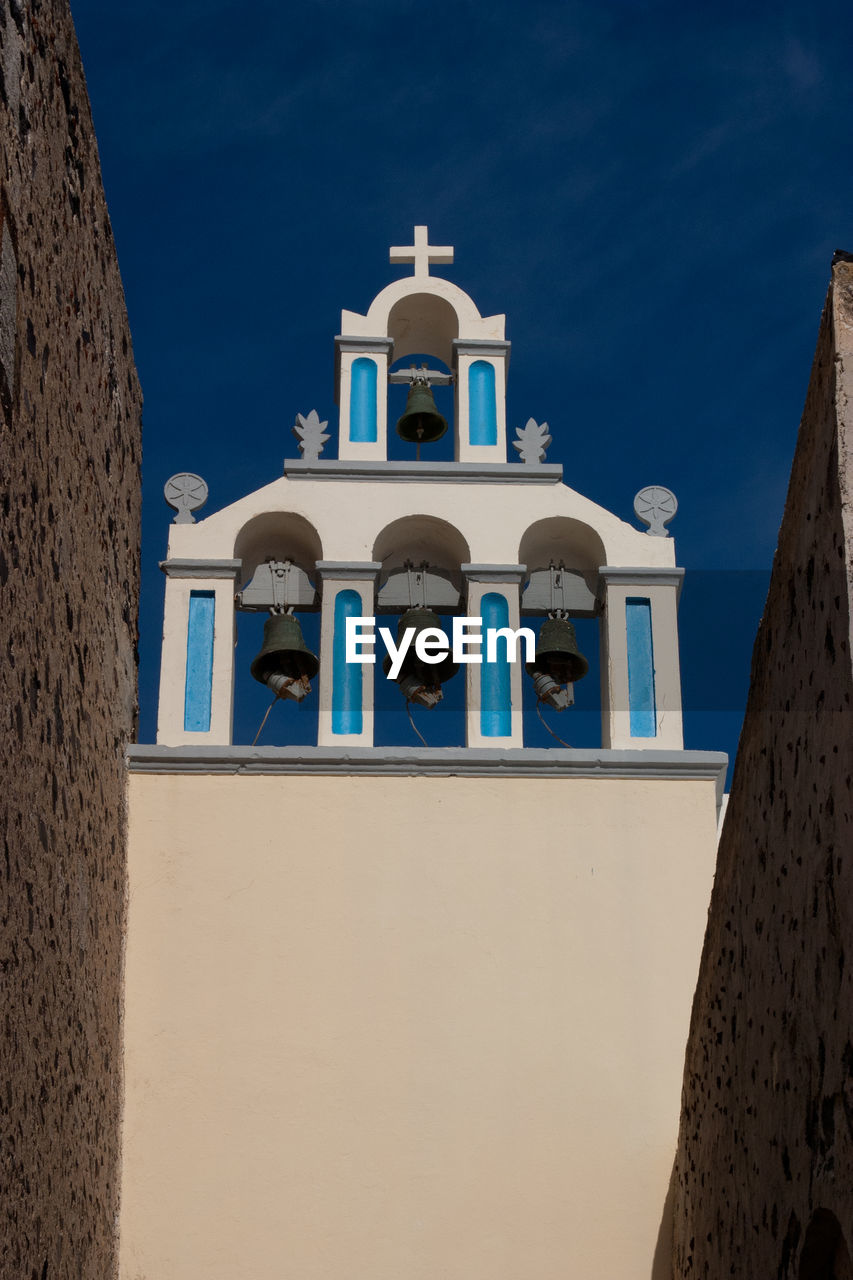 Low angle view of bell tower against blue sky