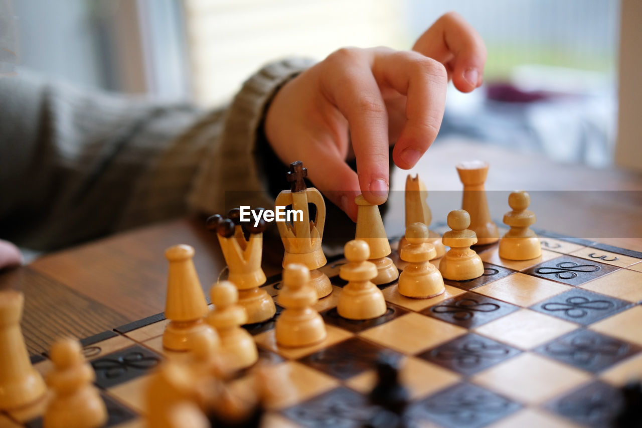 Young player playing chess on the chessboard